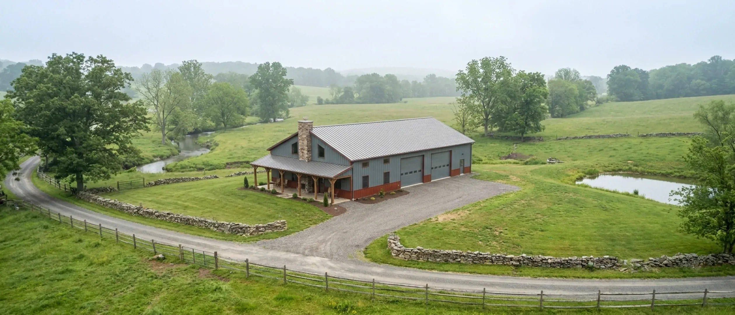 A completed barndominium with a covered entry porch and an attached shop bay, photographed in flat overcast daylight.